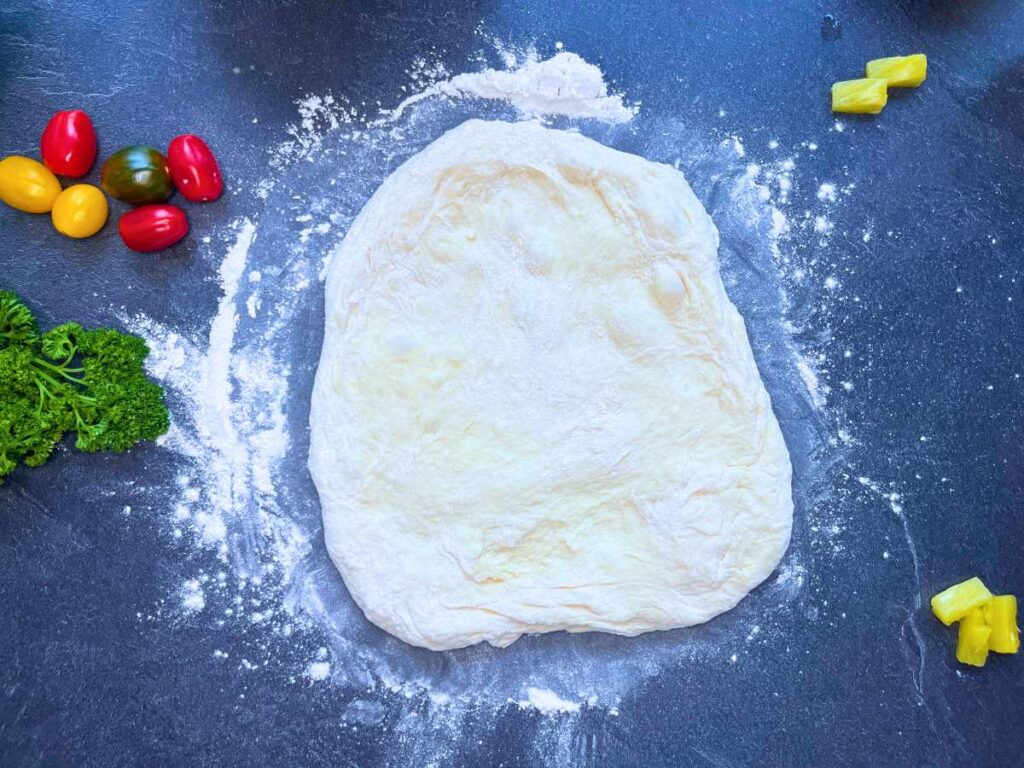 Pizza dough on a slate table.