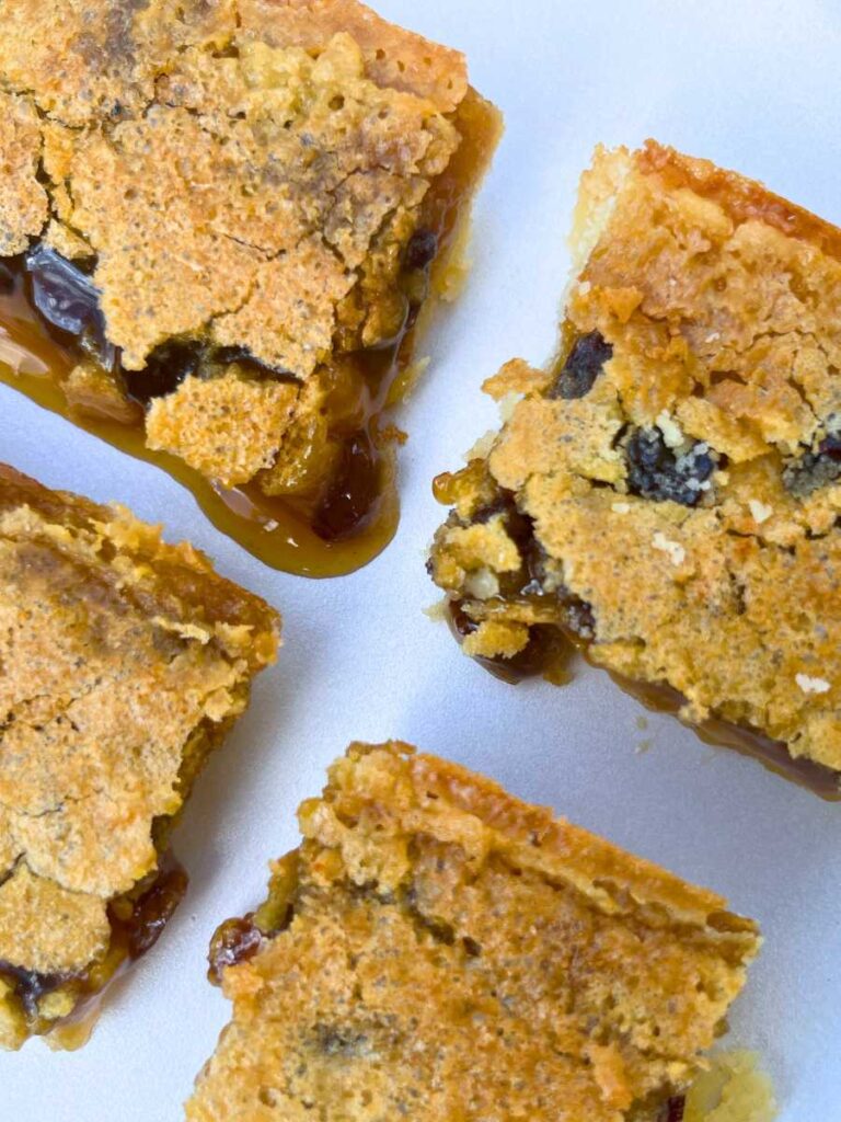 Sliced butter tart bars on a piece of parchment paper.