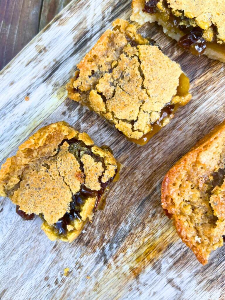 Sliced butter tart squares on a wooden cutting board.