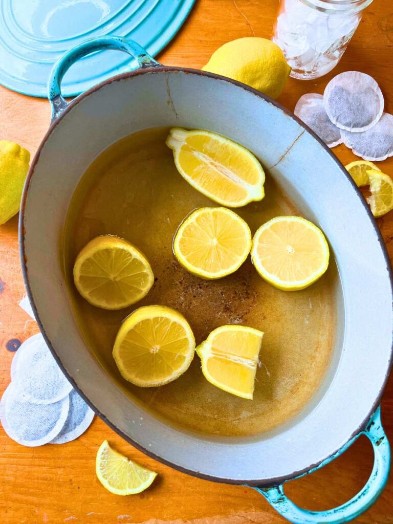 Sliced lemons in a large pot of water.