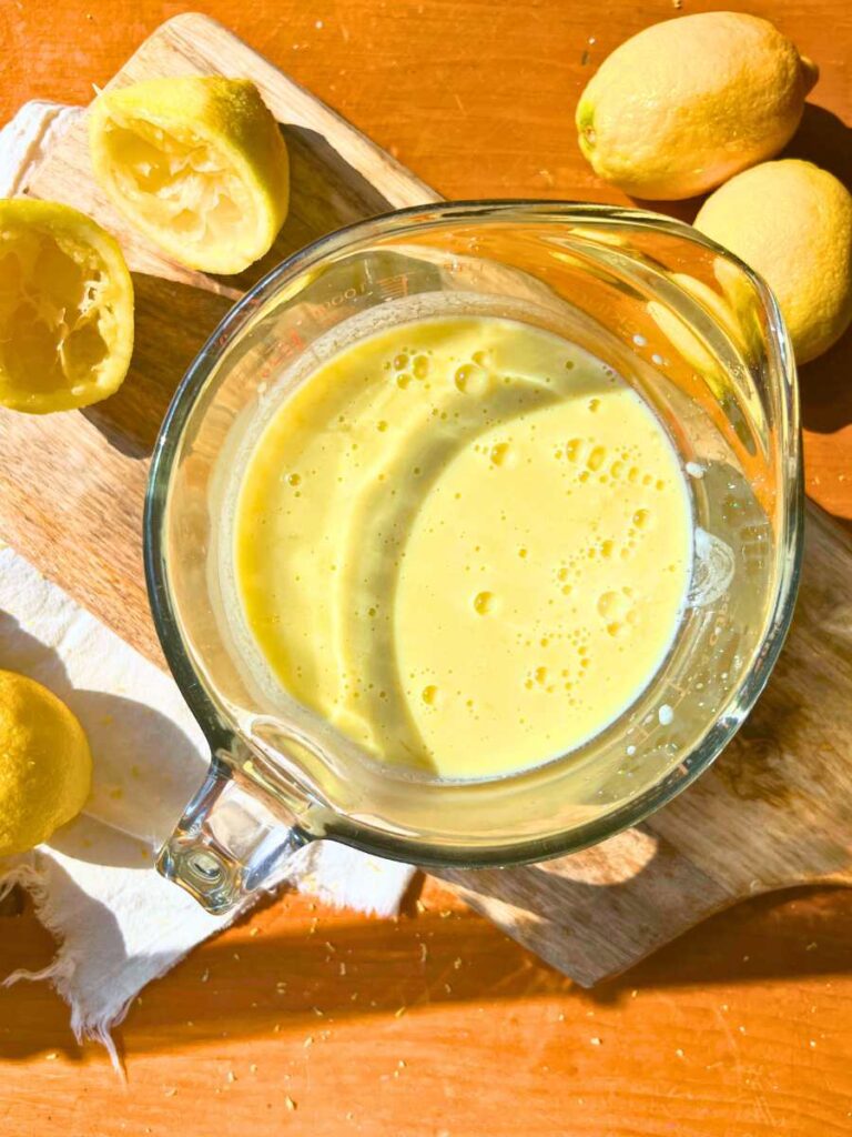 A large glass measuring cup filled with a liquid lemon gelato mixture.