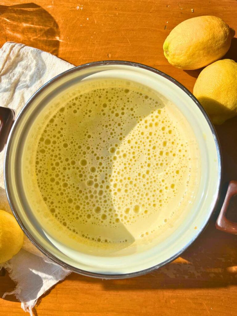 A sauce pot with egg yolk, sugar, and milk inside.