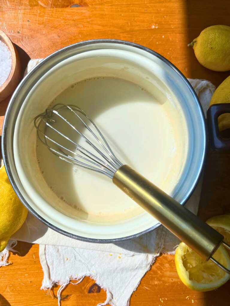 A white sauce pot with a cornstarch and water mixture inside.