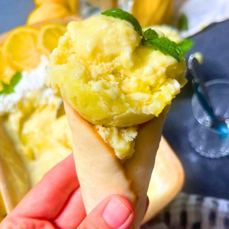 A woman is holding a homemade cone filled with lemon gelato.