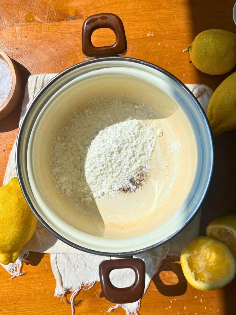 A white sauce pot filled with sugar, cornstarch, and salt.