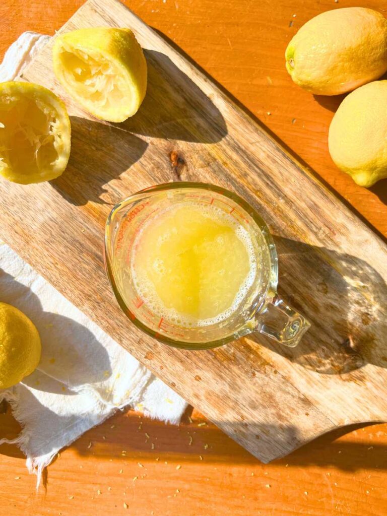 A glass measuring cup filled with lemon juice.