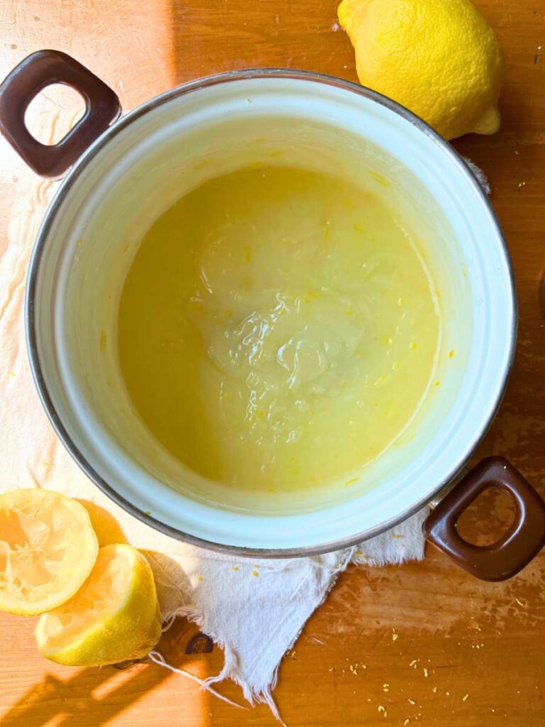 A thickened lemon and cornstarch mixture in a white sauce pot.