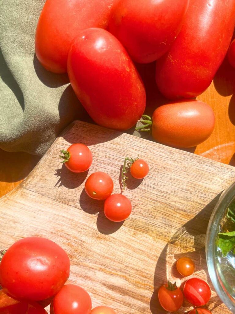 A wooden table with fresh tomatoes.
