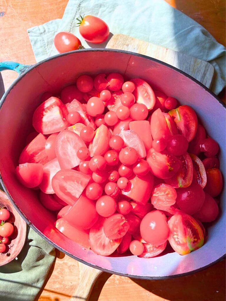 A large Dutch oven filled with sliced tomatoes.