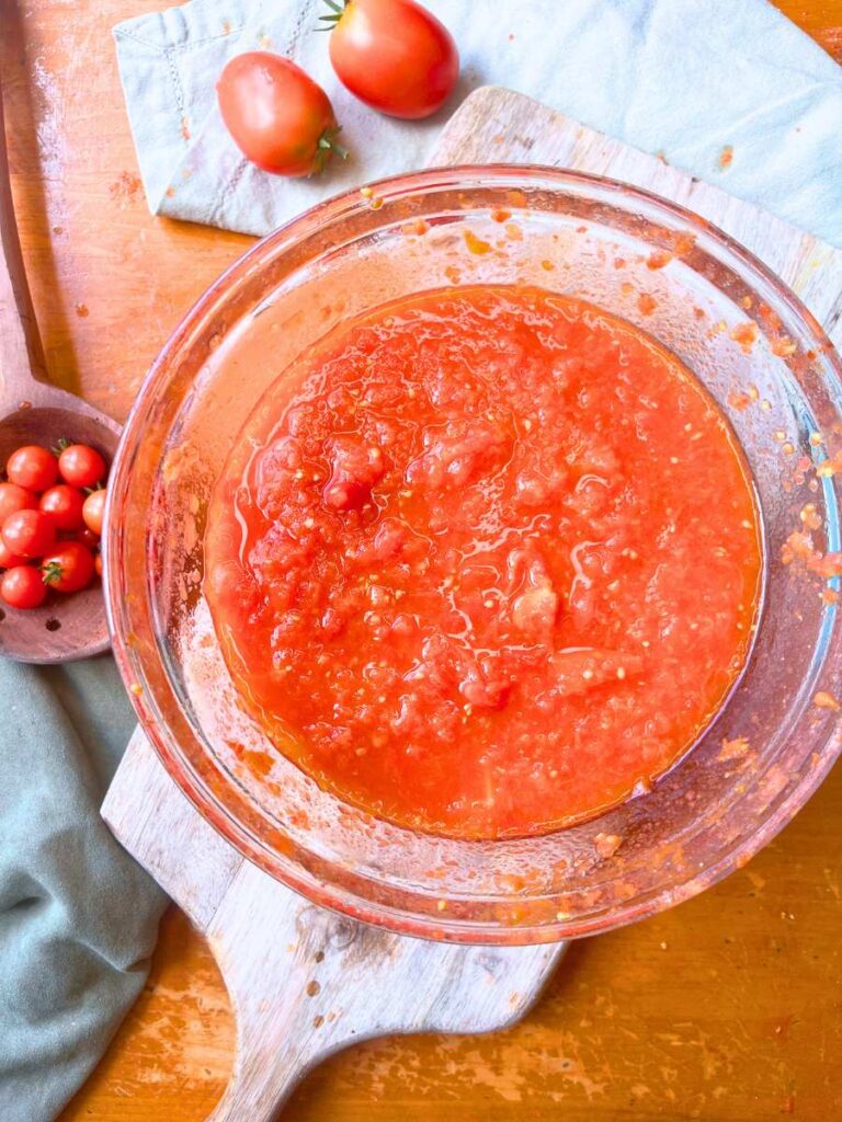 A glass bowl filled with fresh tomato sauce.