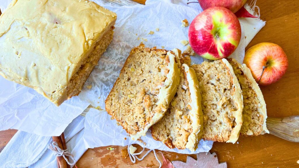 A sliced apple loaf cake with a caramel icing on top.