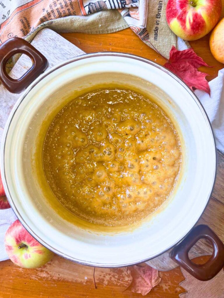 A white sauce pot with cooked caramel icing inside.