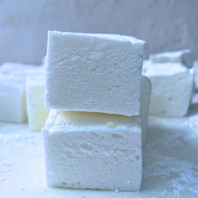 Two stacked homemade marshmallows. There is more in the background.