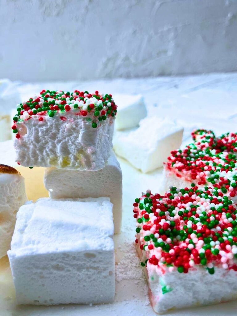 Homemade marshmallows that have a red and green sprinkle topping.