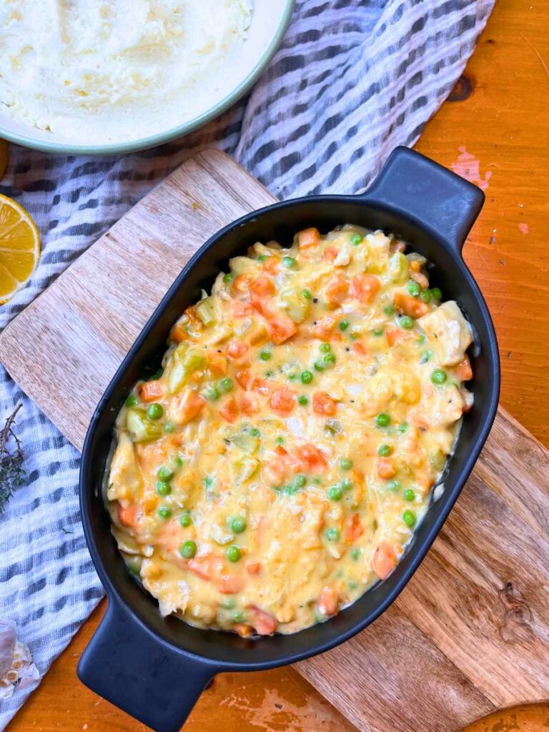 A casserole dish with a turkey and vegetable filling inside.