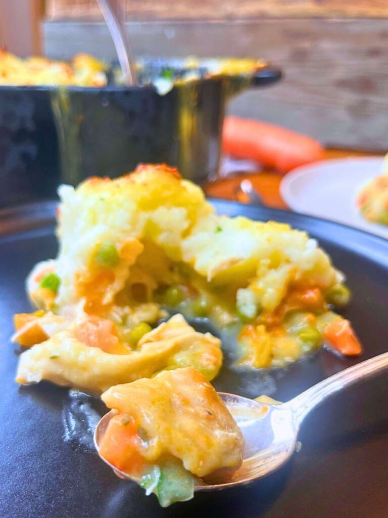 A serving of turkey shepherd's pie with a spoonful in front.