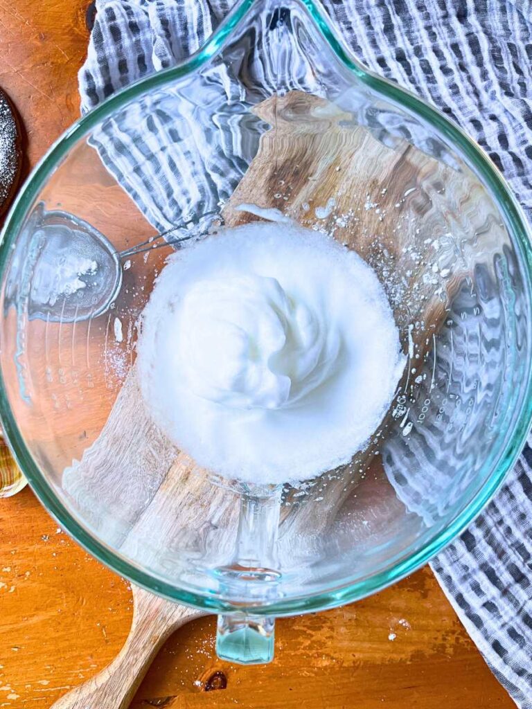 Whipped egg whites in a glass bowl.