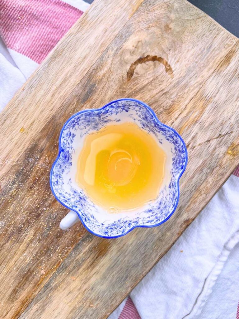 A cracked egg in a blue floral teacup.