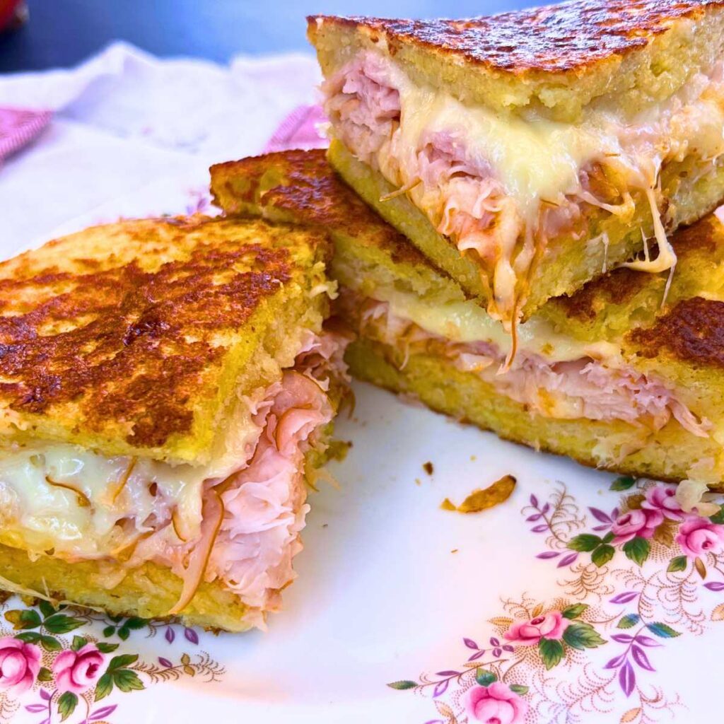 A sliced Monte Cristo sandwich on a pink floral plate.