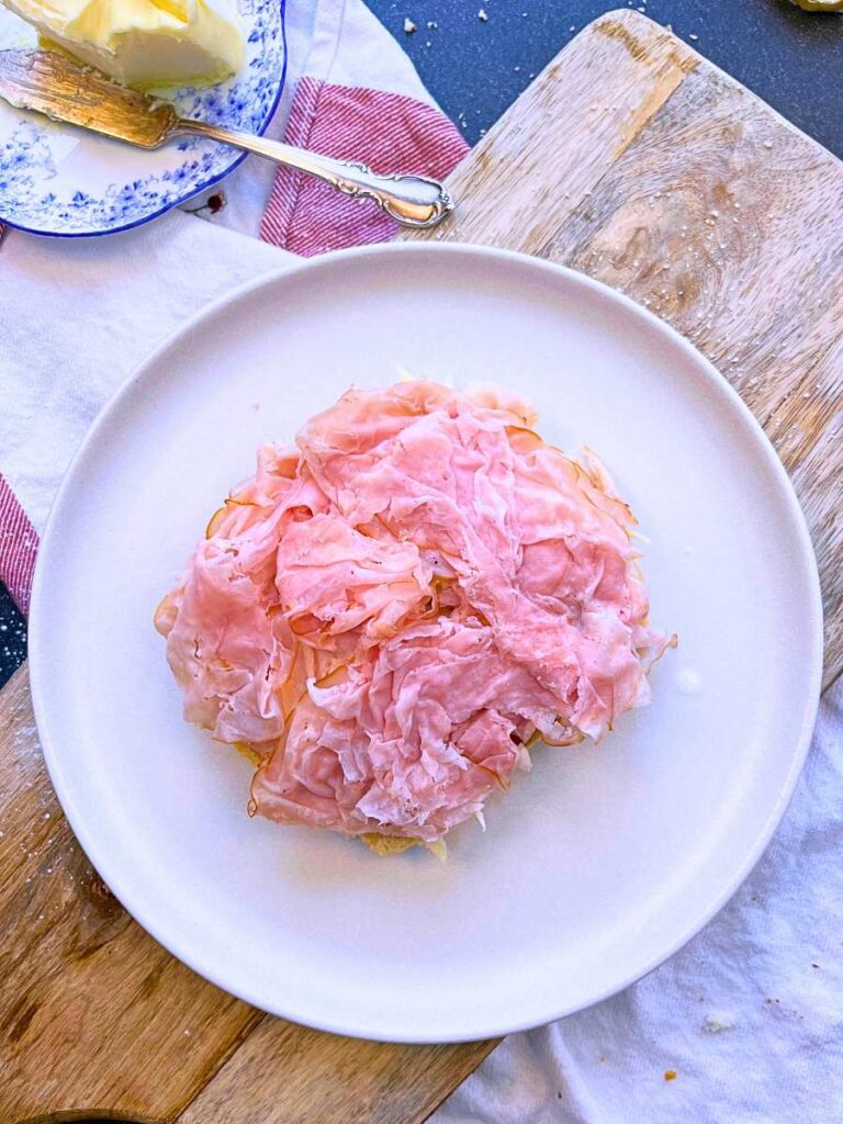 A slice of bread with deli ham on top.