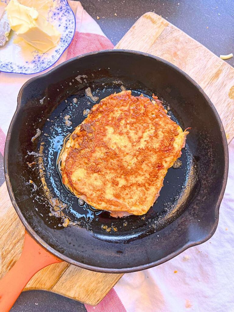 A Monte Cristo sandwich in a frying pan.