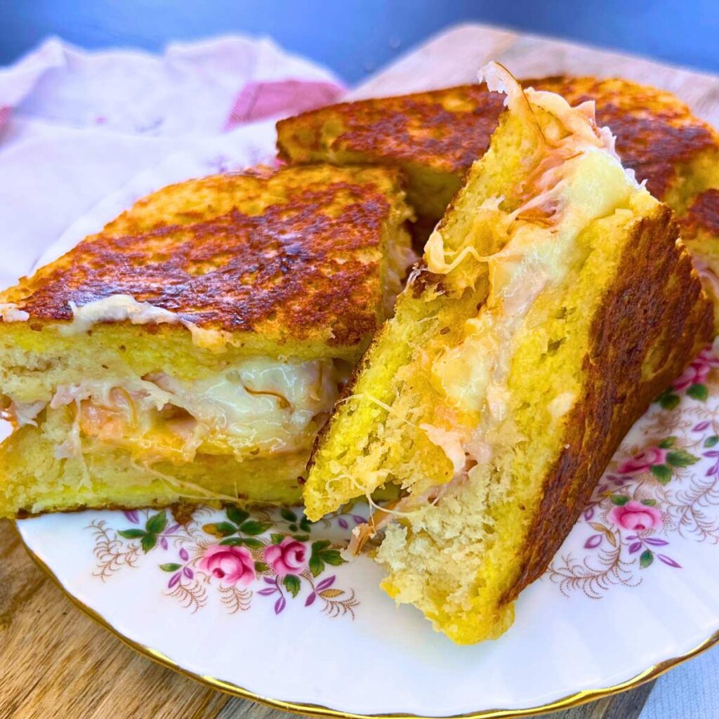 A sliced Monte Cristo sandwich on a pink floral plate.