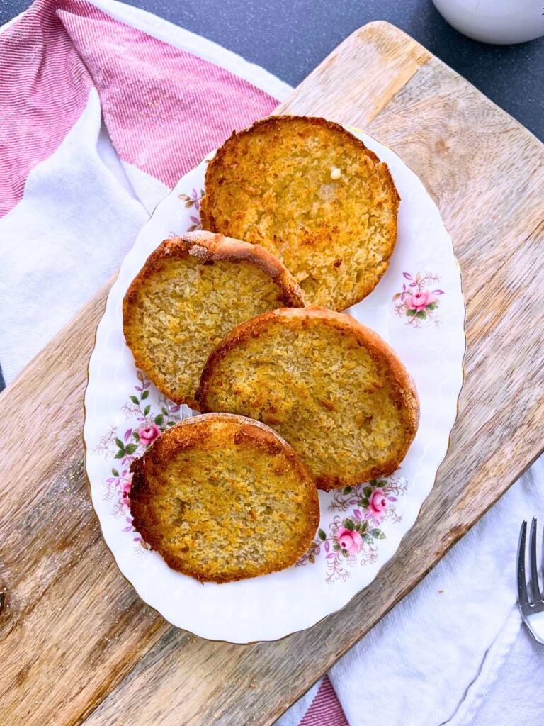 Toasted English muffins on a pink floral plate.