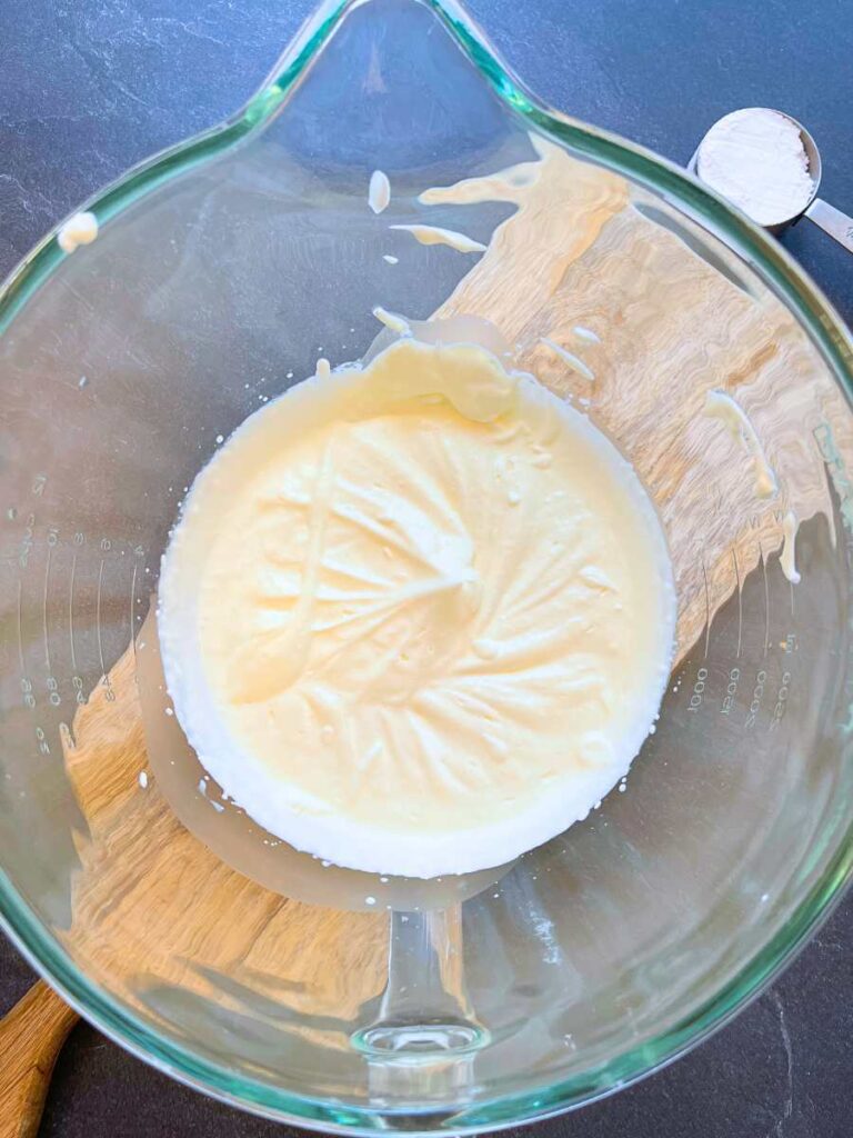 A glass bowl full of whipped cream.