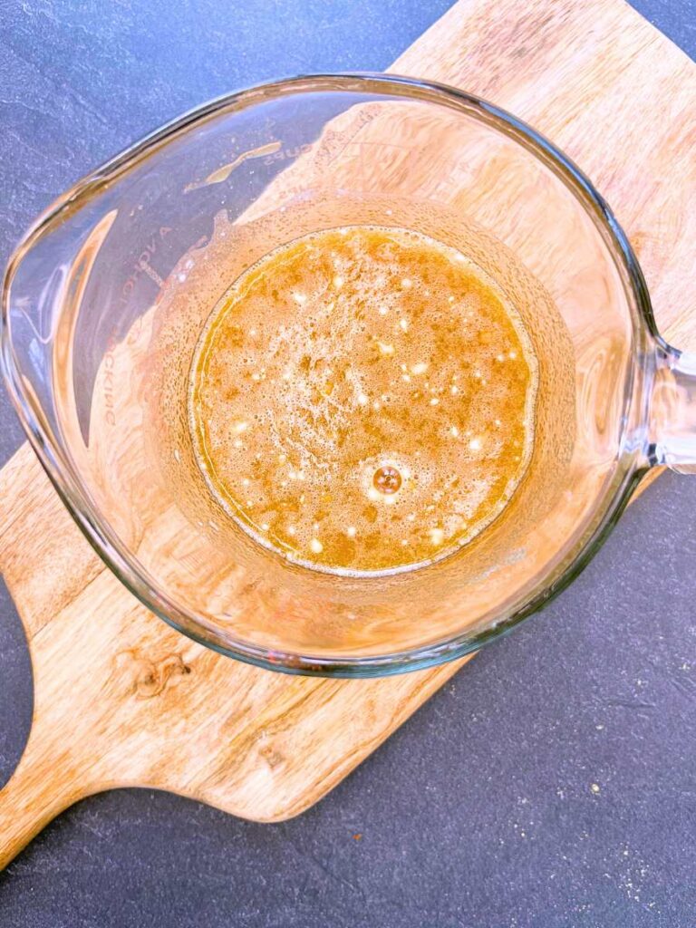 A large glass measuring cup with a maple and brown sugar mixture inside.