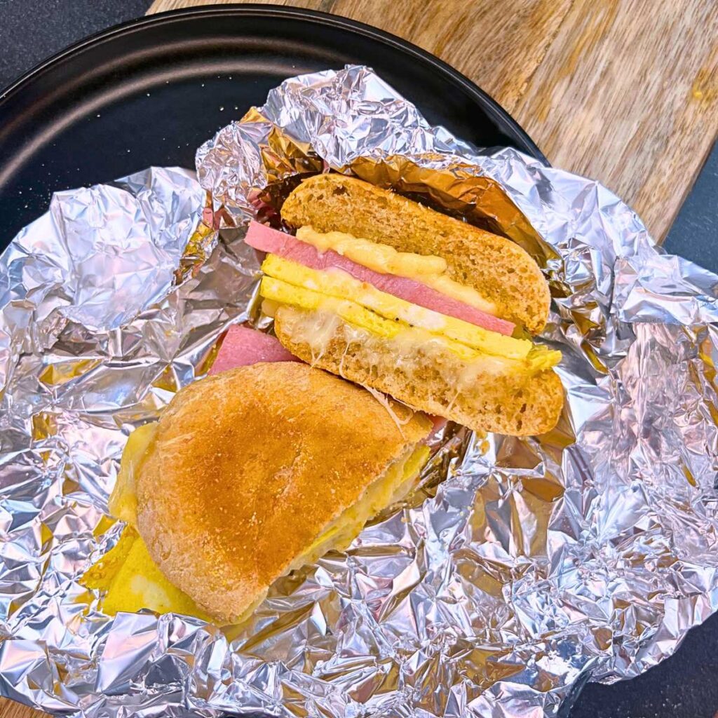 A breakfast sandwich cut in half. It is in tinfoil.