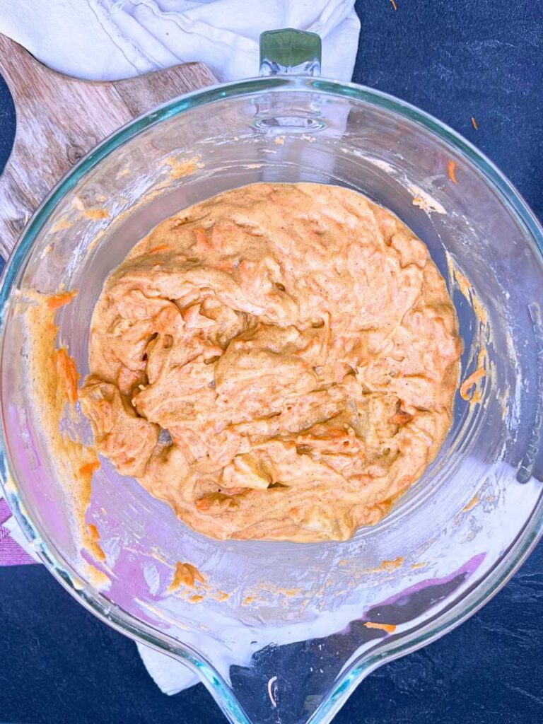 A large glass bowl filled with carrot cake batter.