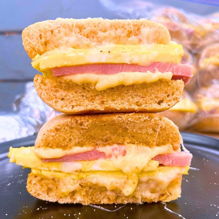 A warmed breakfast sandwich that has been split in half. Both sides are stacked together.