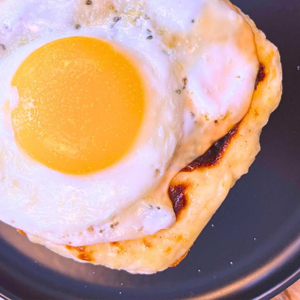 An overhead view of a croque madame sandwich with a sunny-side-up egg on top.