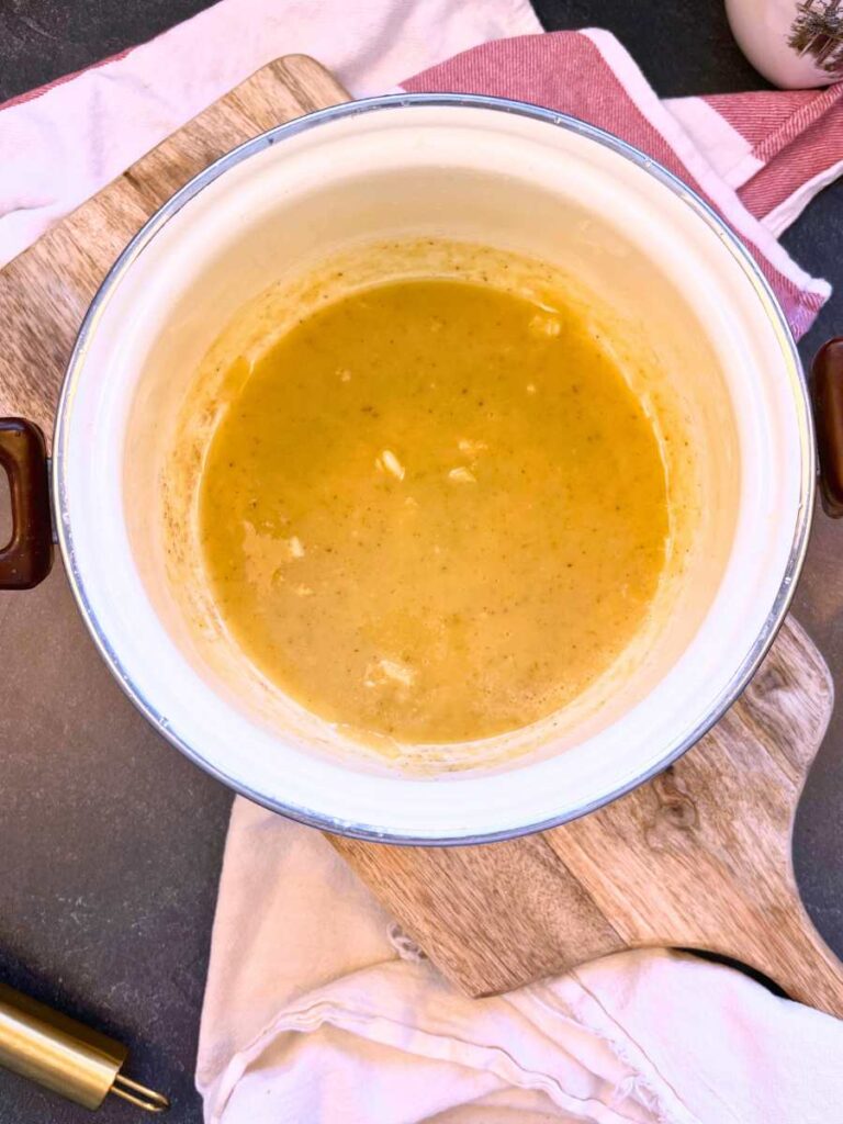 A white sauce pot with butter and garlic.