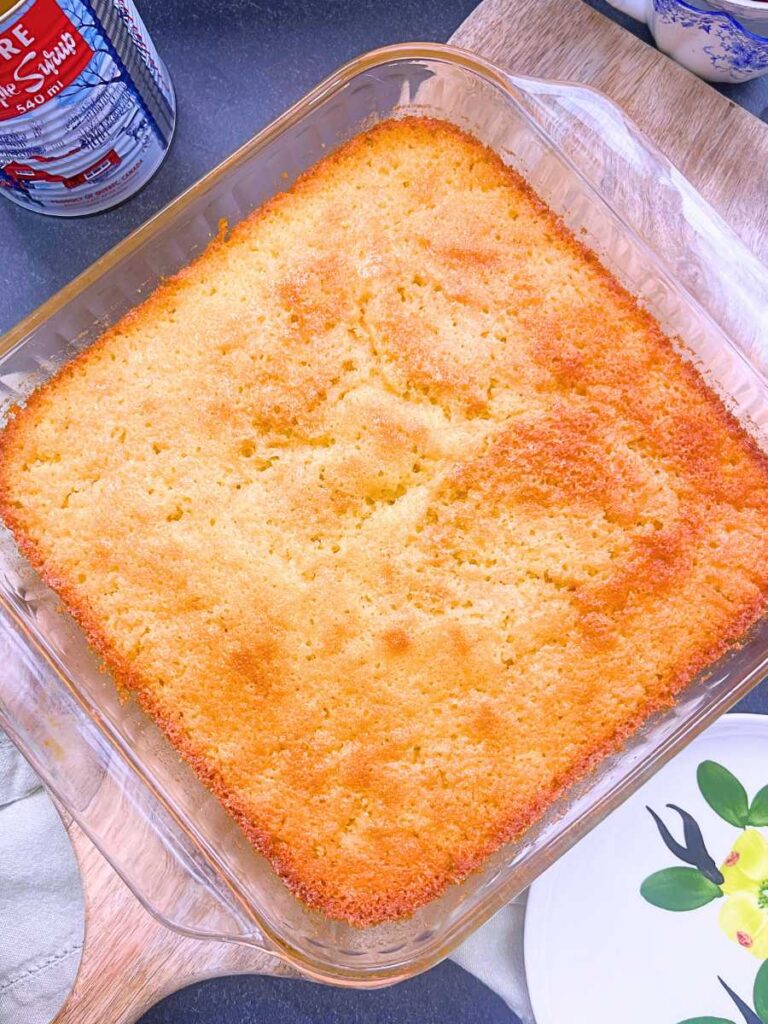 A baked pouding chômeur in a square casserole dish.