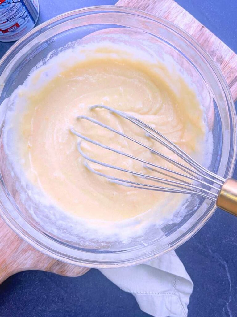 A glass bowl with a cake batter inside.