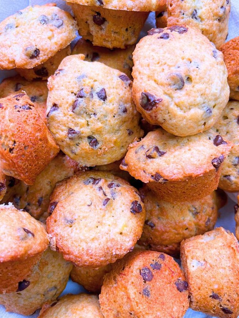 An overhead view of a collection of mini muffins with chocolate chips inside.