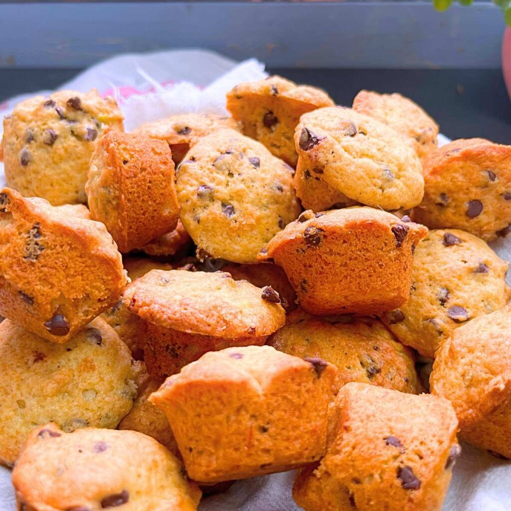A lined basket with mini chocolate chip muffins.