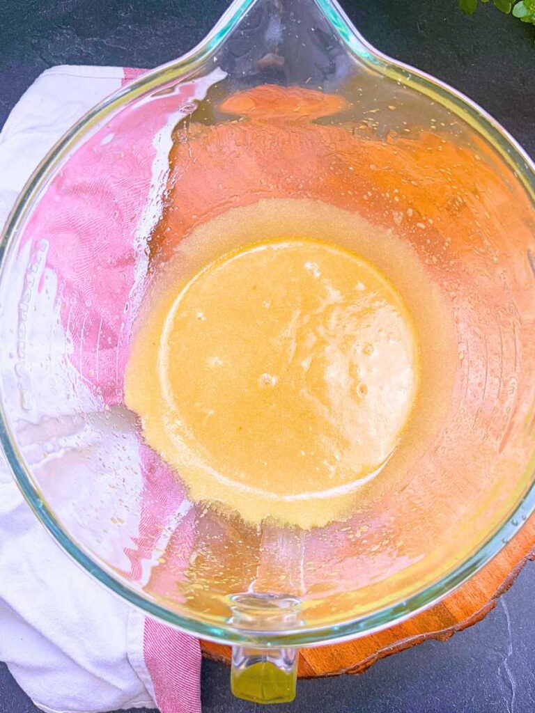 A mixture of melted butter and sugar in a large glass bowl.
