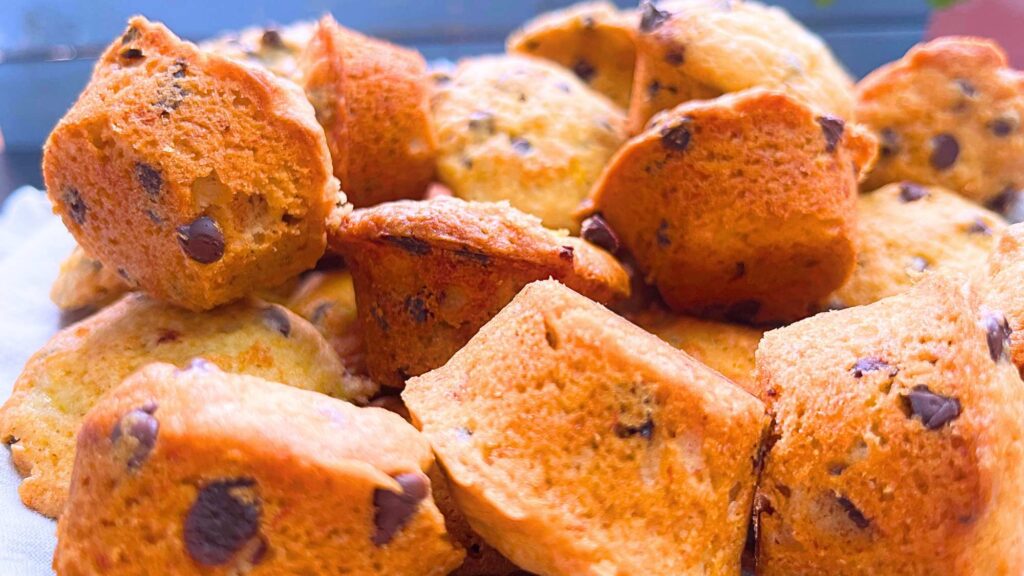 A close up look at a collection of mini banana muffins with chocolate chips inside.