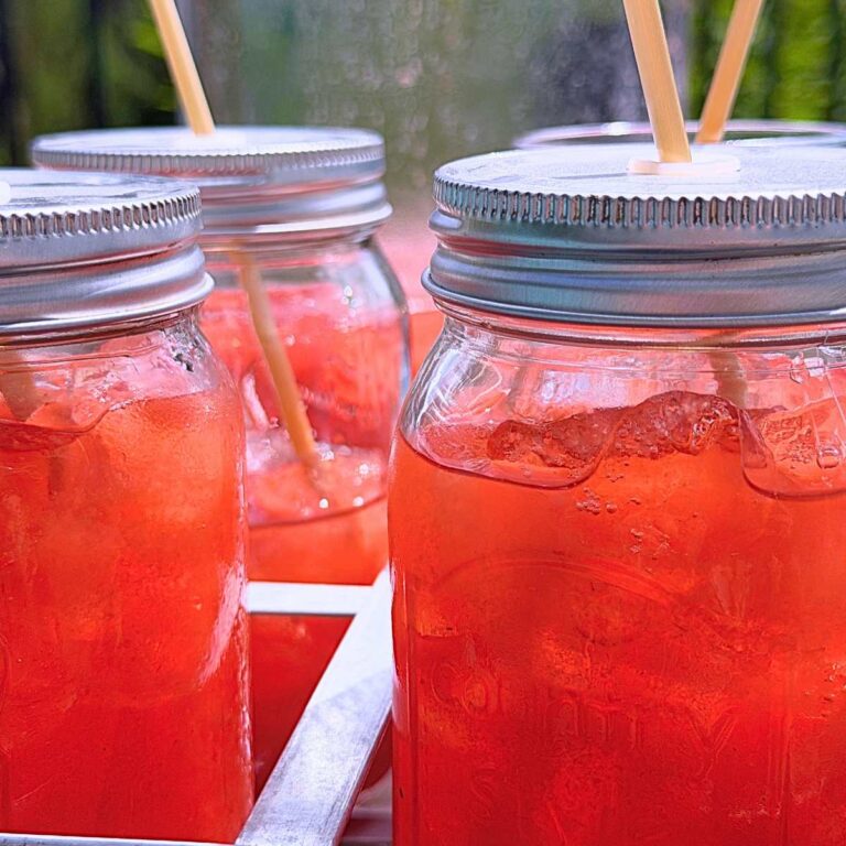 Some jar glasses of homemade strawberry iced tea.