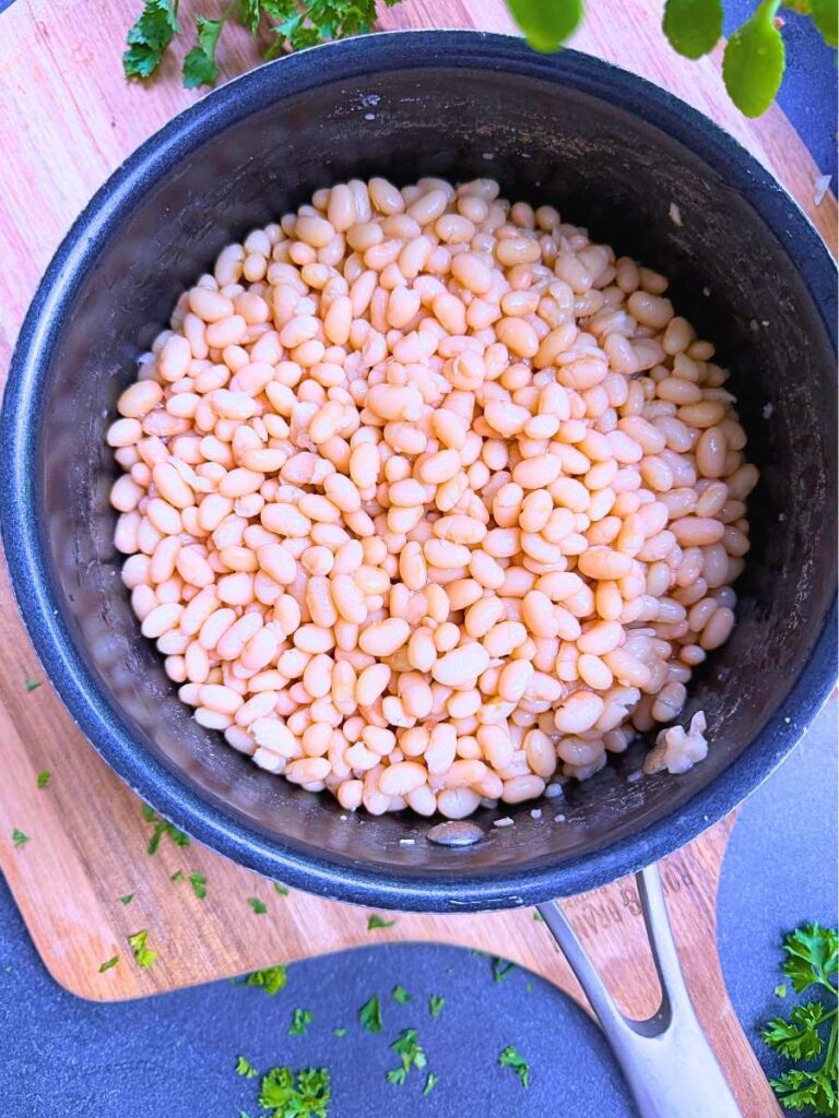 A black pot filled with white navy beans.