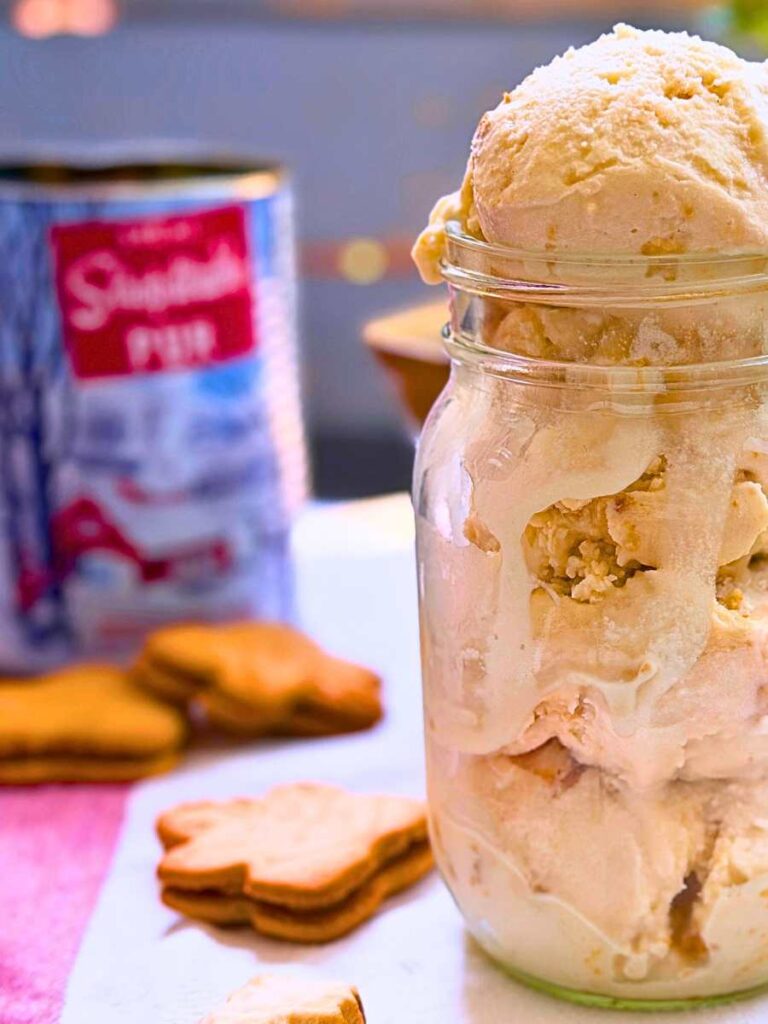Homemade maple ice cream in a canning jar. There are maple cookies and a tin of maple syrup in the background.
