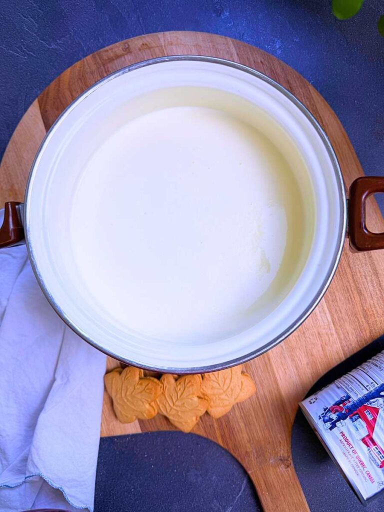 A white sauce pot with an ice cream mixture inside.
