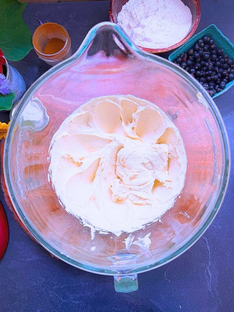 A glass bowl with a creamed sugar and butter mixture inside.