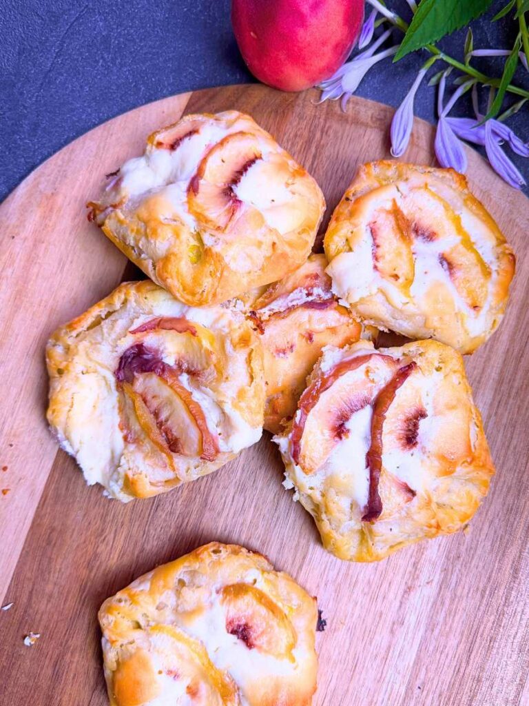 Baked Danishes with sliced peaches on top.