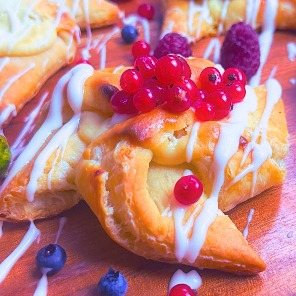 A sourdough cheese danish topped with red currents.