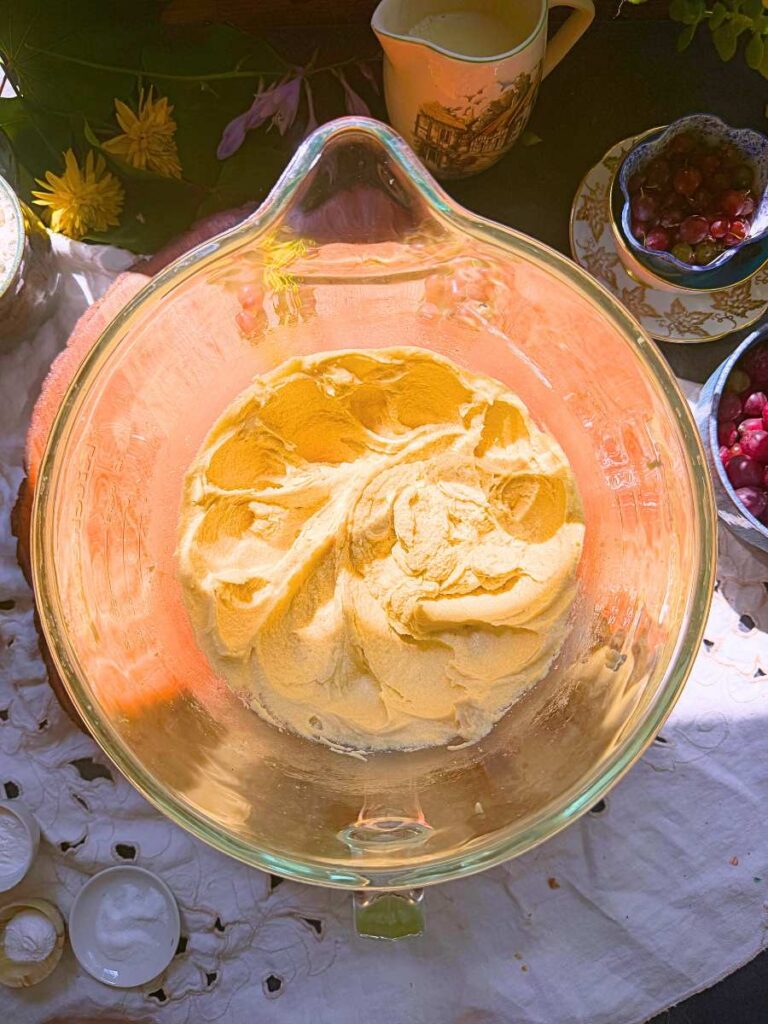 A glass bowl with creamed butter, sugar, and eggs.