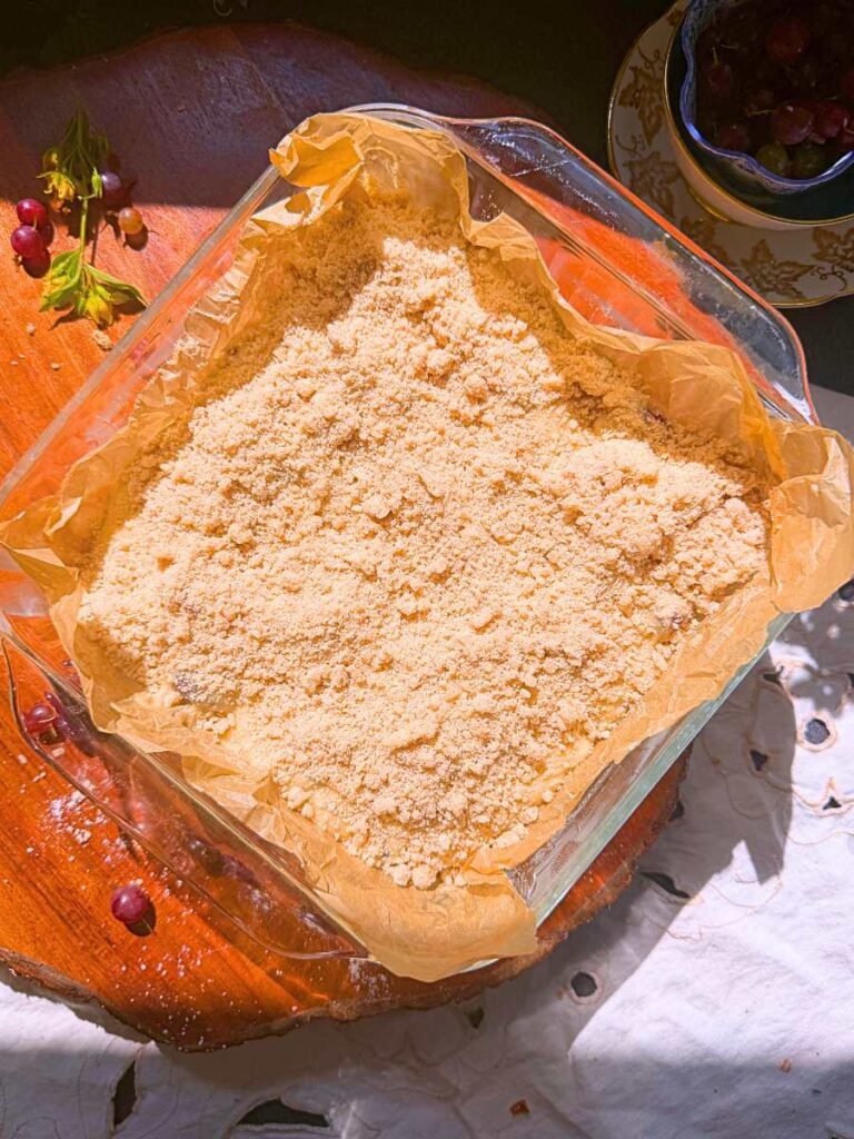Coffee cake batter with streusel topping in a glass baking dish.