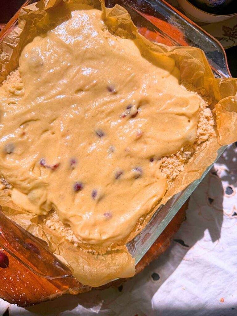 Gooseberry coffee cake batter on top of a streusel layer.